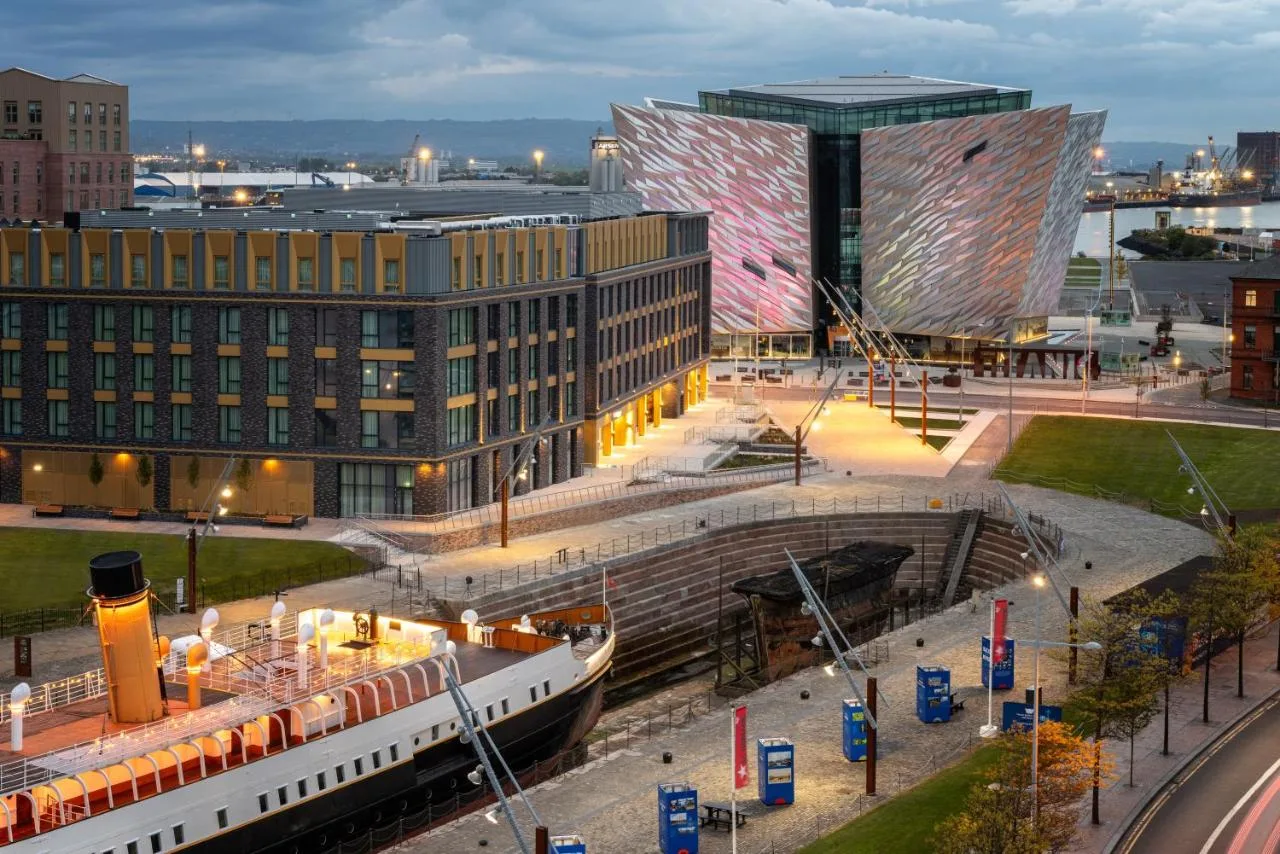 a large building with a train in front of it at Residence Inn by Marriott Belfast Titanic Quarter in Belfast